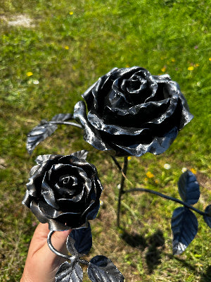 Here is a large metal steel rose head that is sitting next to standard steel rose head. you can see the detail is magnified in the larger rose. All Handmade by Blacksmith Justin 