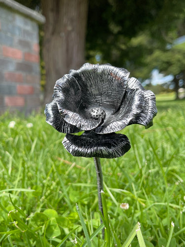 Steel Poppy, showing an ANZAC like oppy made from mild steel in the grass outside 