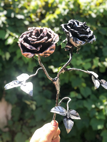 a double headed rose made from both steel and copper in the sun glinting 